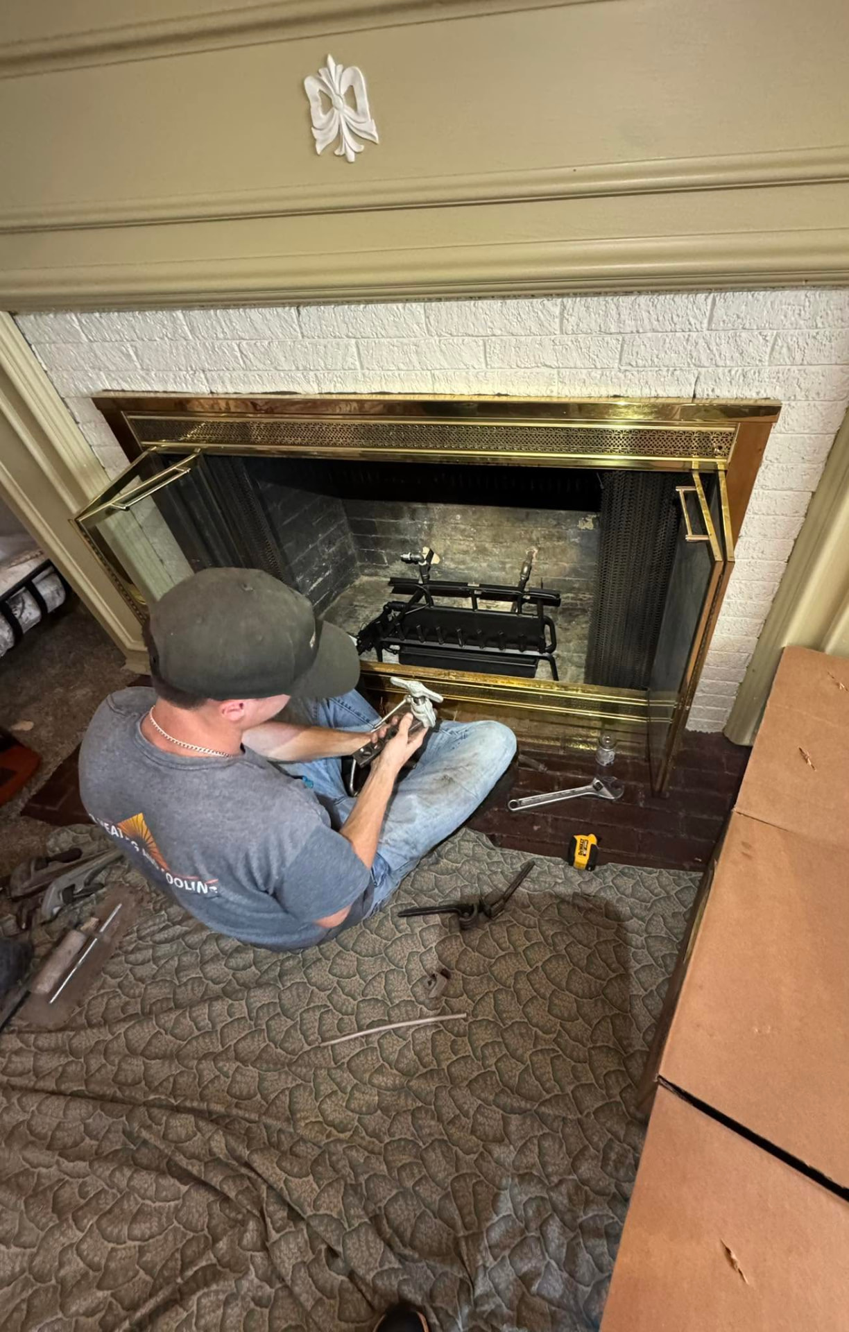32 Heating and Cooling technician installing gas logs in a residential fireplace