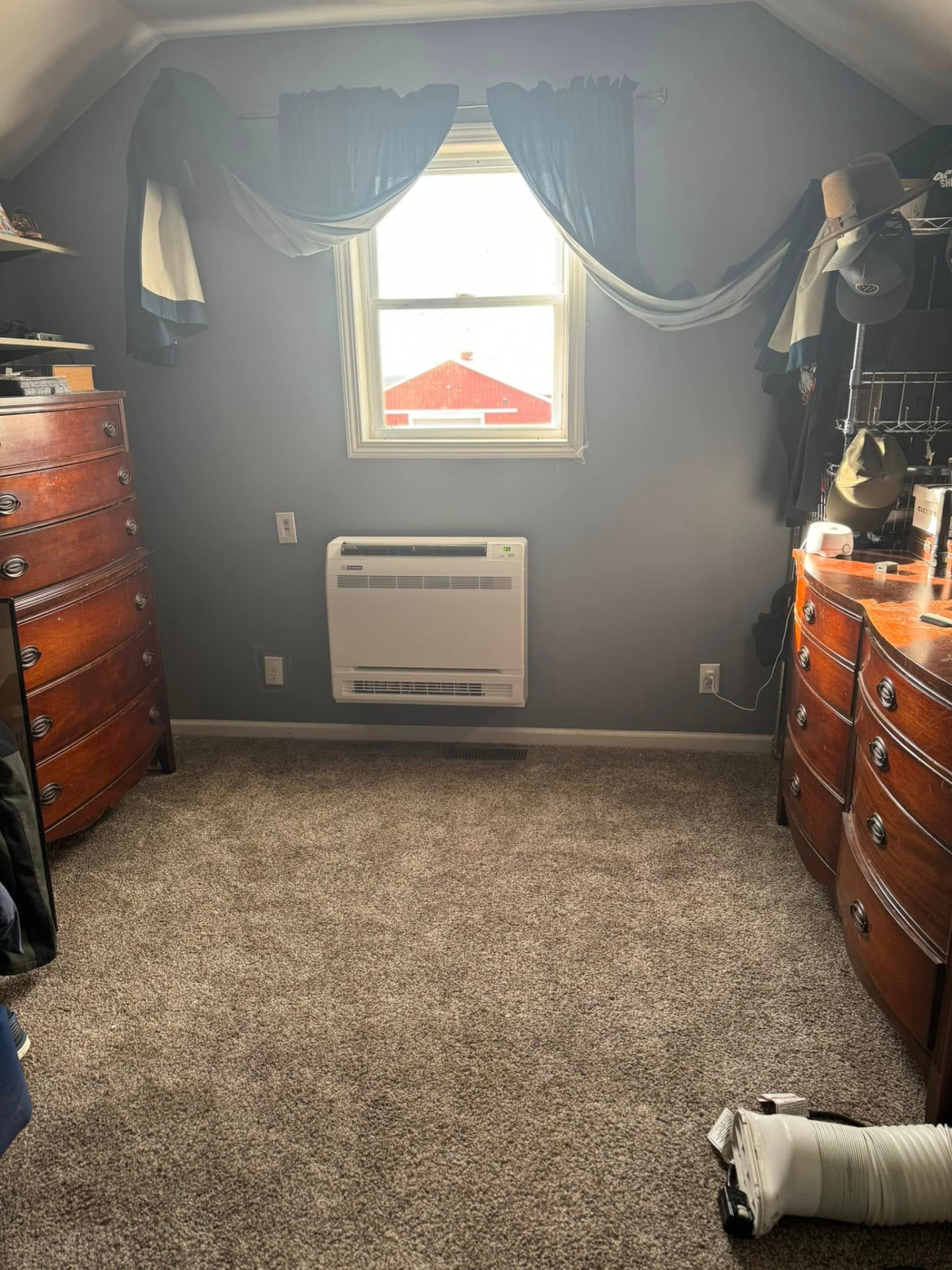 Floor-mounted ductless mini-split head heating and cooling an upstairs bedroom