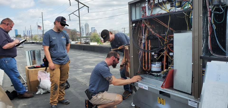 32 Heating and Cooling crew servicing a commercial rooftop HVAC unit