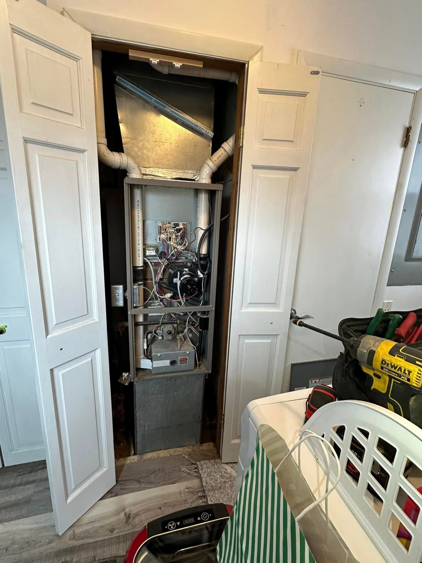 Closet furnace opened for service showing blower, control board, and burner assembly
