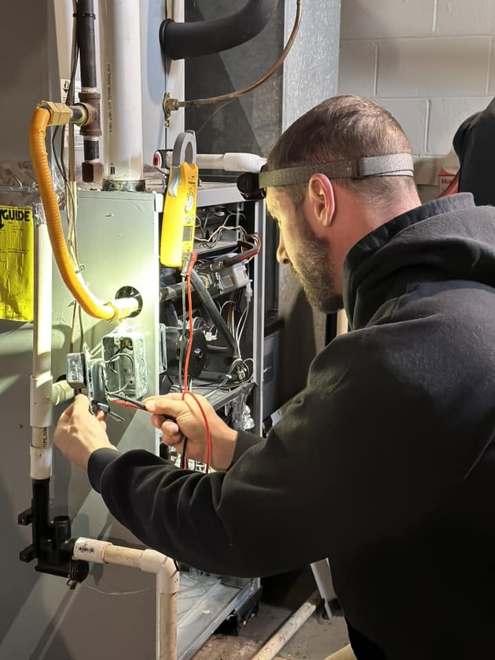 32 Heating and Cooling technician testing furnace wiring with a meter during a heating repair in Crawfordsville, Indiana