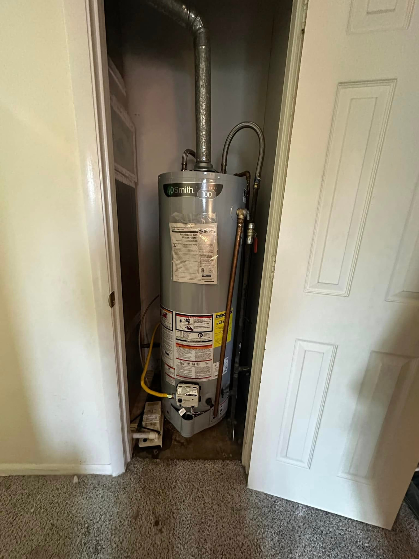 New A.O. Smith gas water heater installed in a hallway closet with fresh venting and gas line